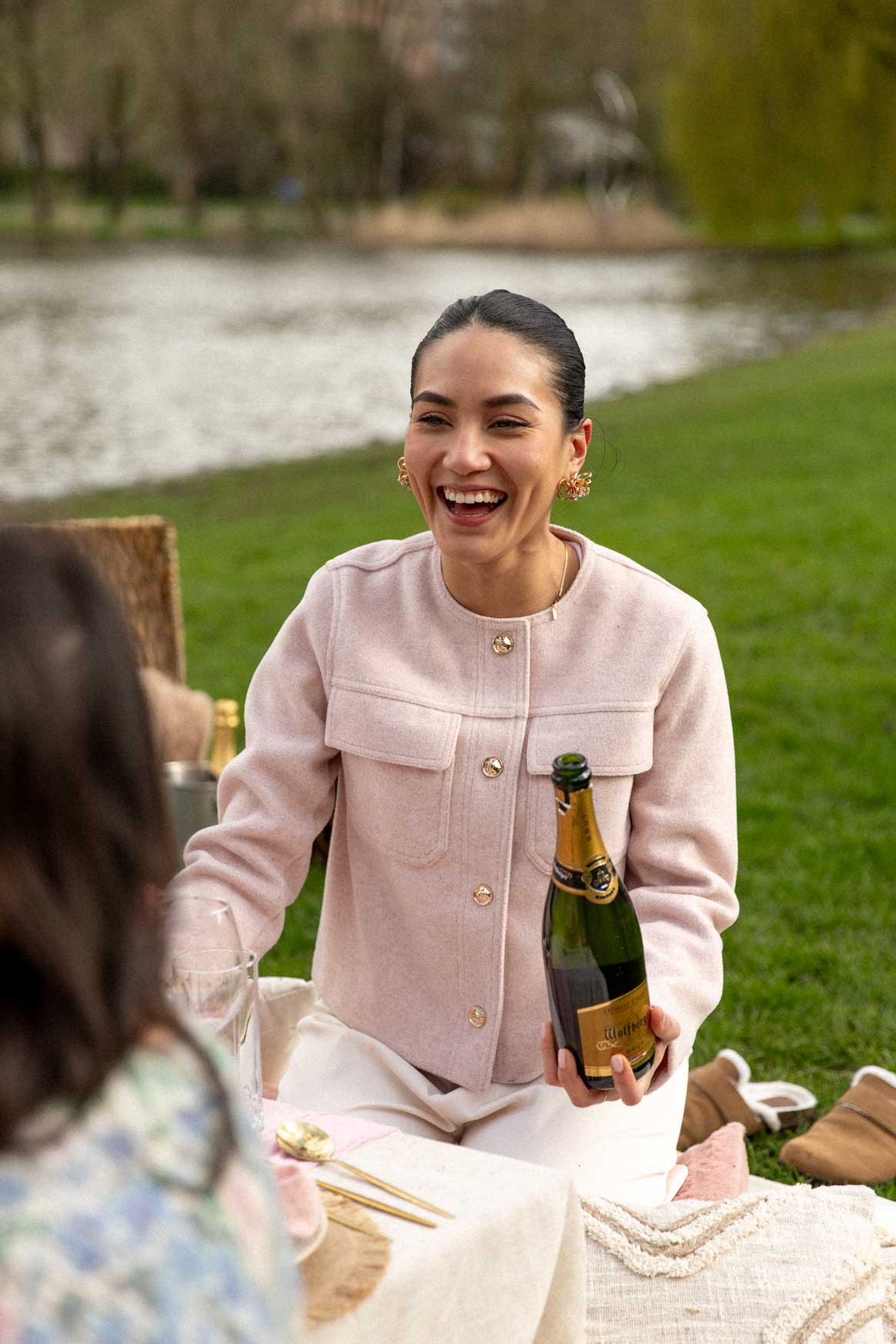Girl popping champagne in park