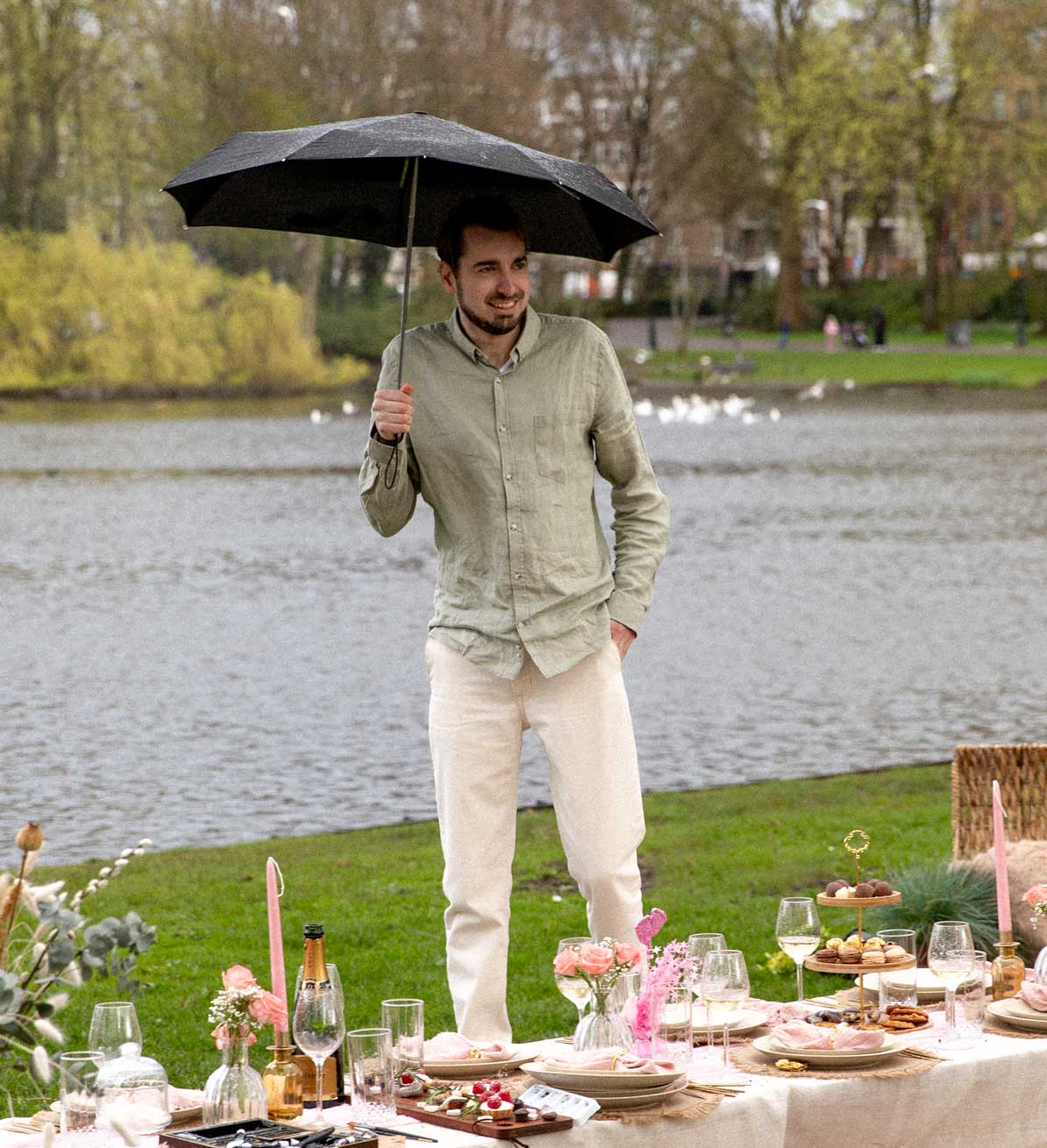 Guy at picnic in park underneath umbrella
